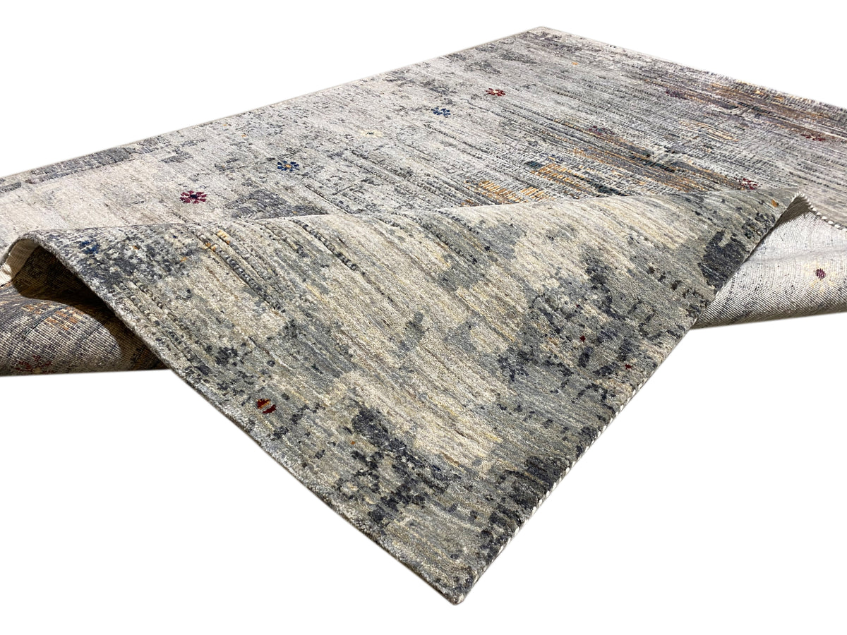 Gabbeh-Luri rug detail: light patterned area with rolled-up edge