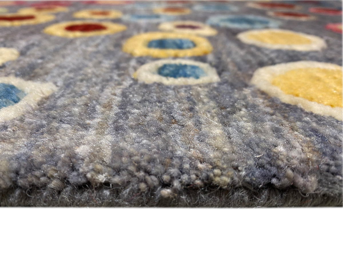 Gabbeh-Luri rug close-up of the pile structure at the edge, gray with colorful circles