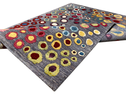 Gabbeh Luri rug shown rolled up: gray background with colorful circular rings