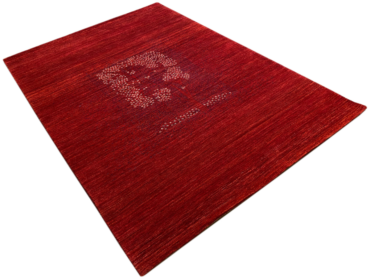 Reddish-brown carpet viewed diagonally with a medallion pattern and mottled pile texture