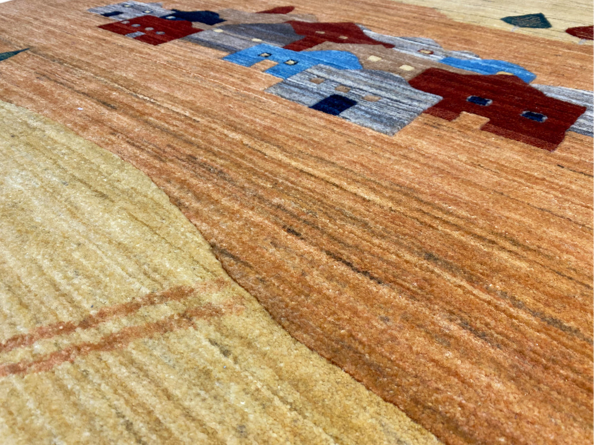 Gabbeh-Luri rug detail with rustic lines and colorful house motifs in brown and blue