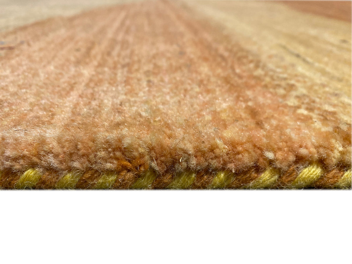 Gabbeh-Luri rug detail at the edge with dense pile in light brown and a greenish background
