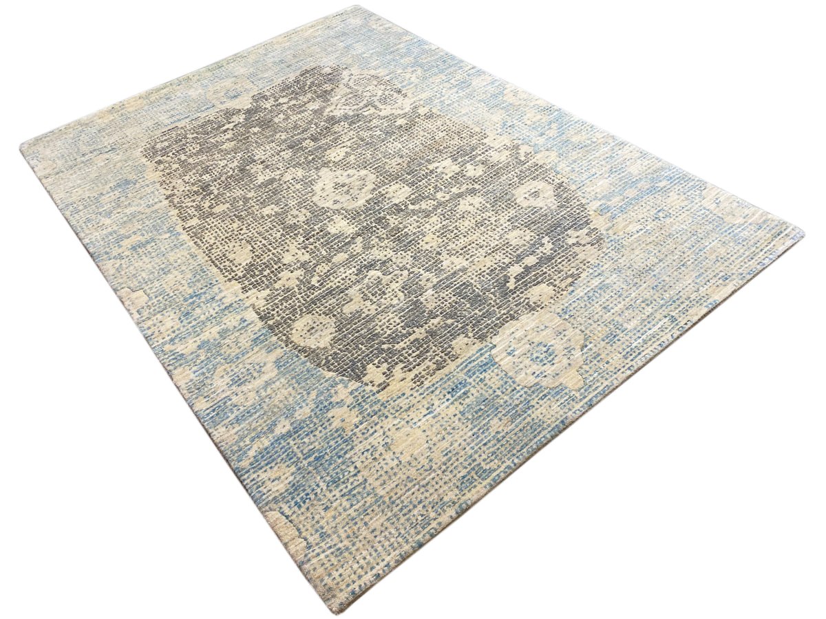 Corner view: blue and gray rug with an abstract relief pattern
