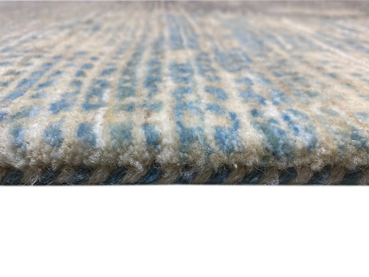 Carpet edge with dense pile, blue-gray patterns, and a beige background