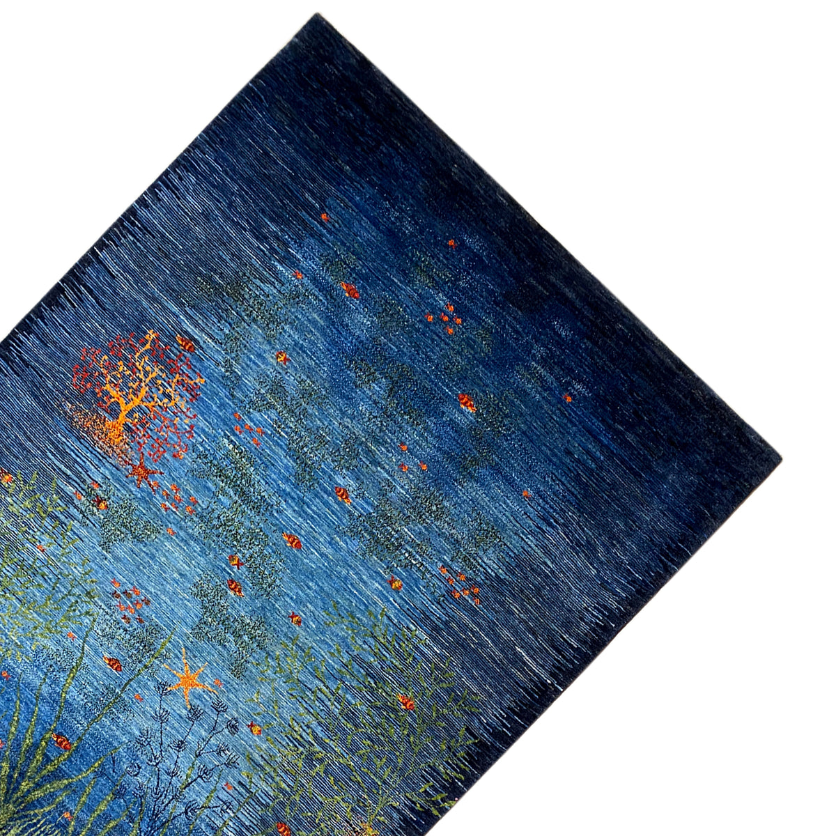 Carpet corner: blue pattern with light green branches and an orange flower cluster