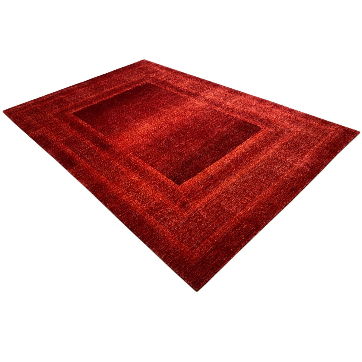 Red Gabbeh Luri rug with a geometric medallion, lying diagonally