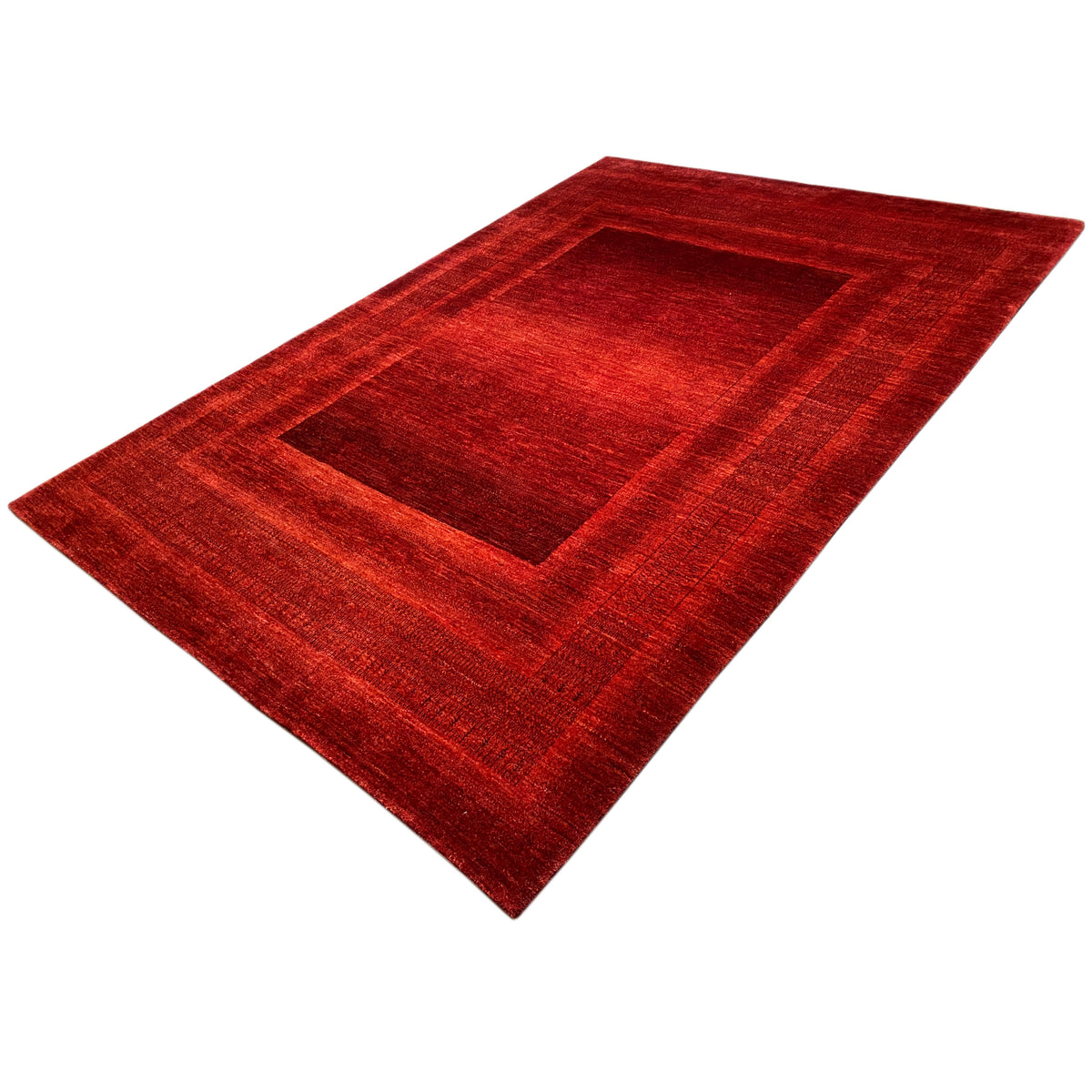 Red Gabbeh Luri rug with a wide border and medallion, angled