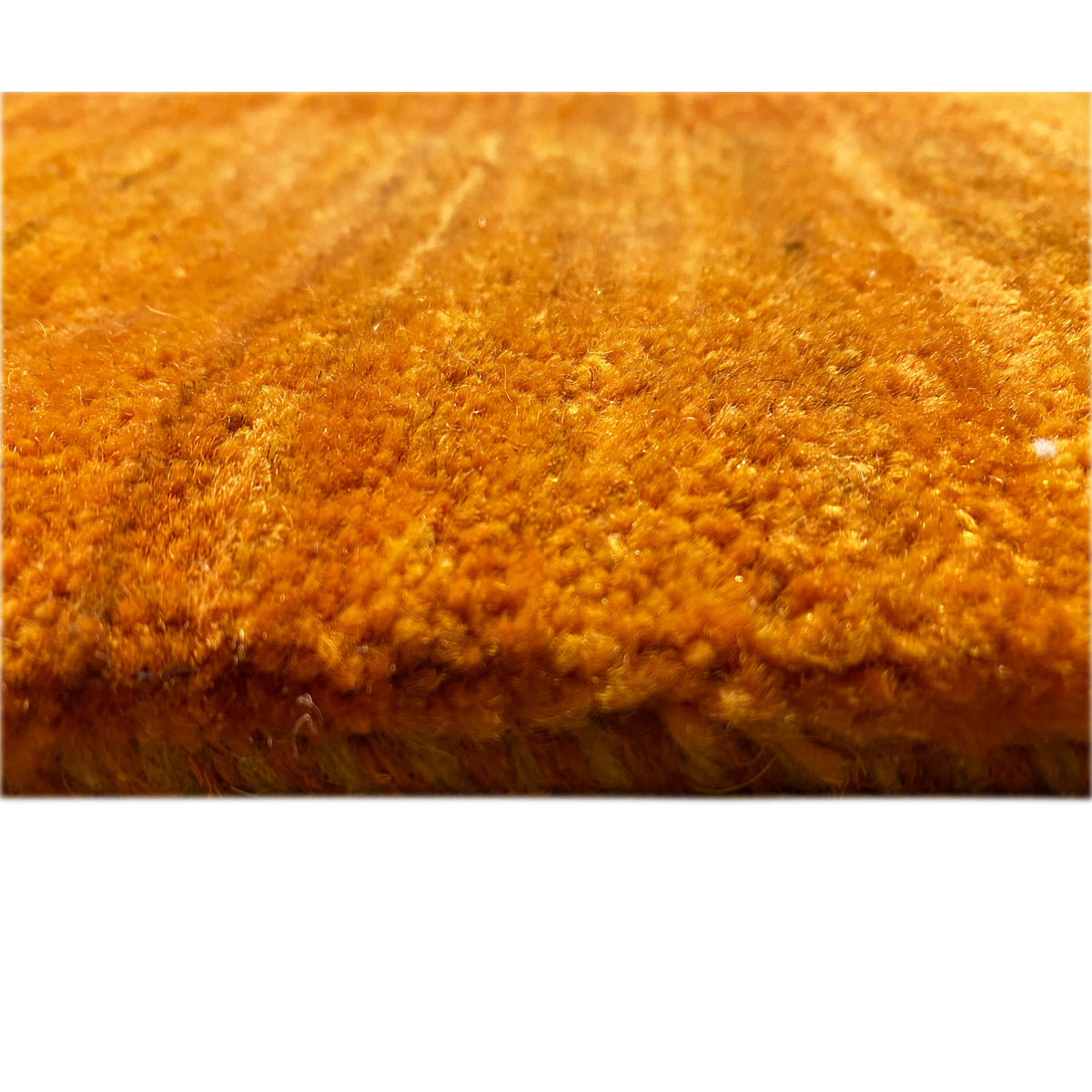 Close-up of a Gabbeh rug: dense pile in warm brown-orange tones