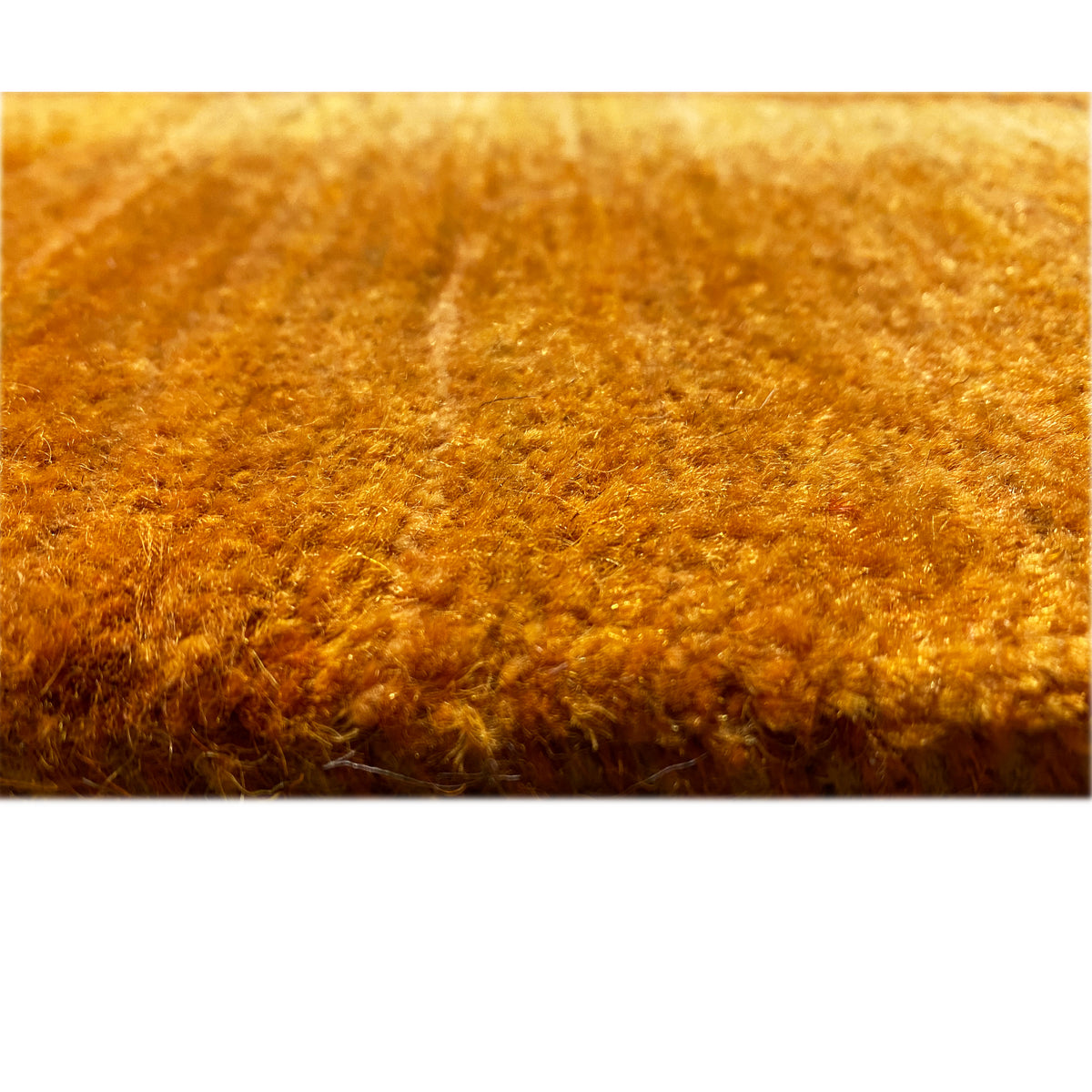 Carpet pile, appearing dense and soft, in a honey-brown color