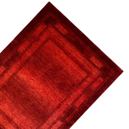 Detailed view: red Gabbeh-Luri rug with a central motif and darker border pattern