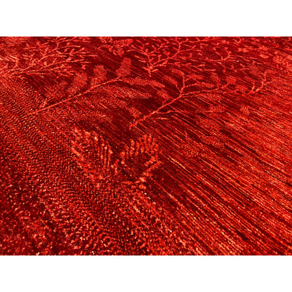 Close-up of a red carpet surface with woven floral lines and texture