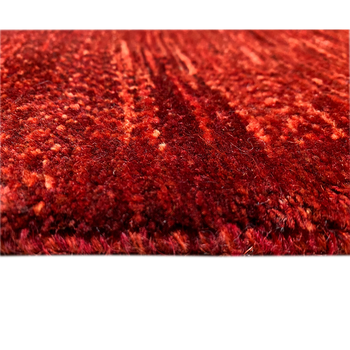 Close-up of red carpet fibers with a dense floral pattern and mottled look
