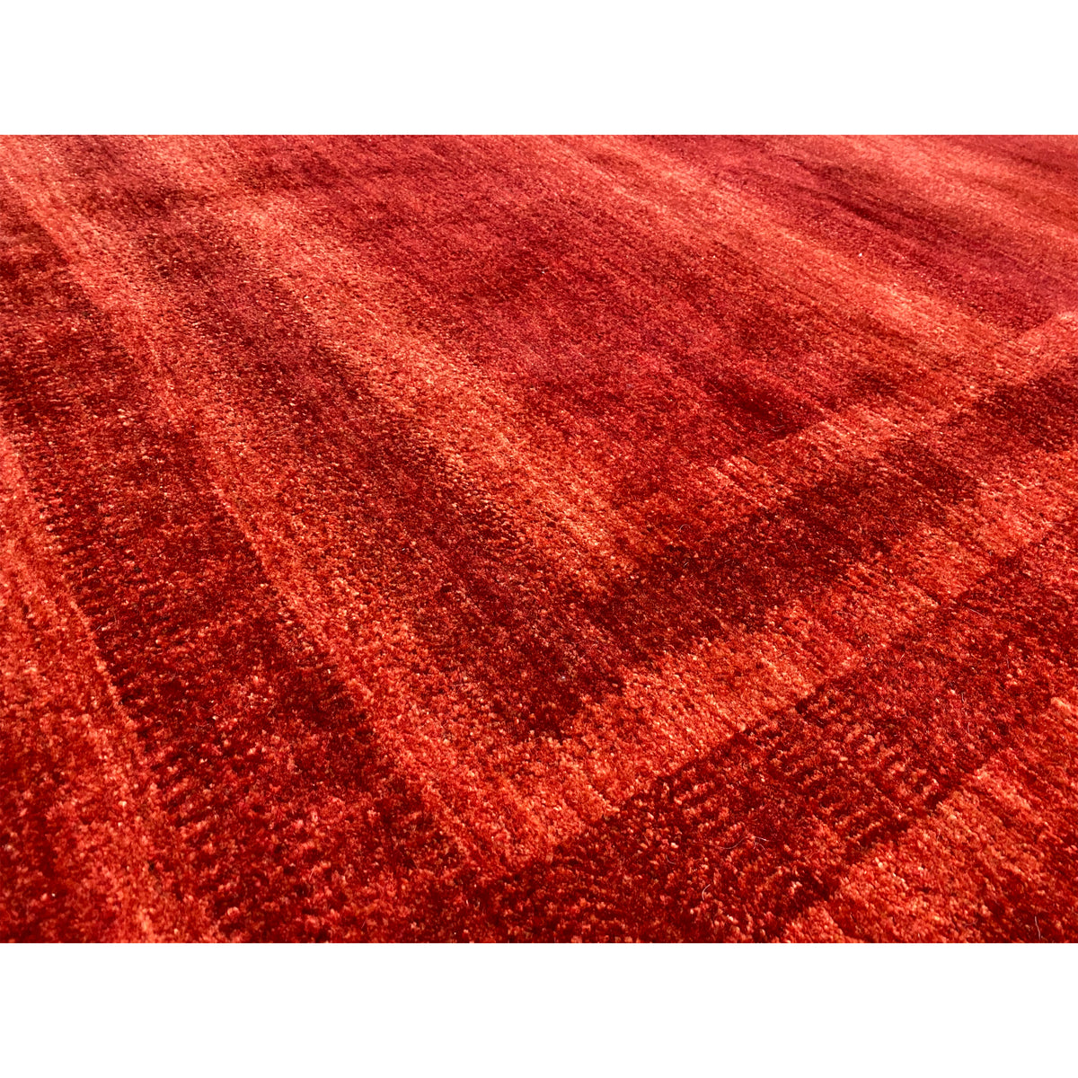 Close-up of a red carpet surface with a dense texture and fine pattern lines