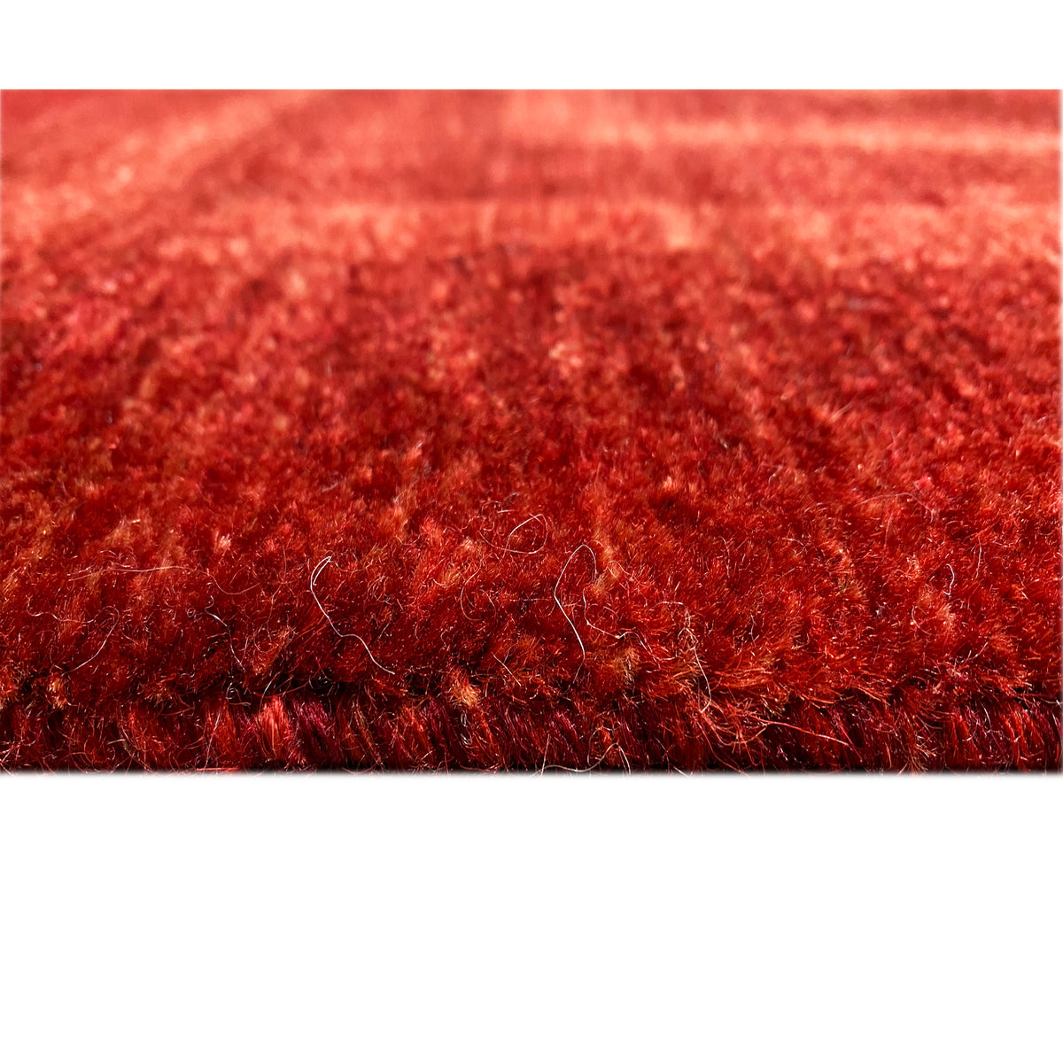 Close-up of carpet pile with a dense reddish-brown fiber texture at the edge