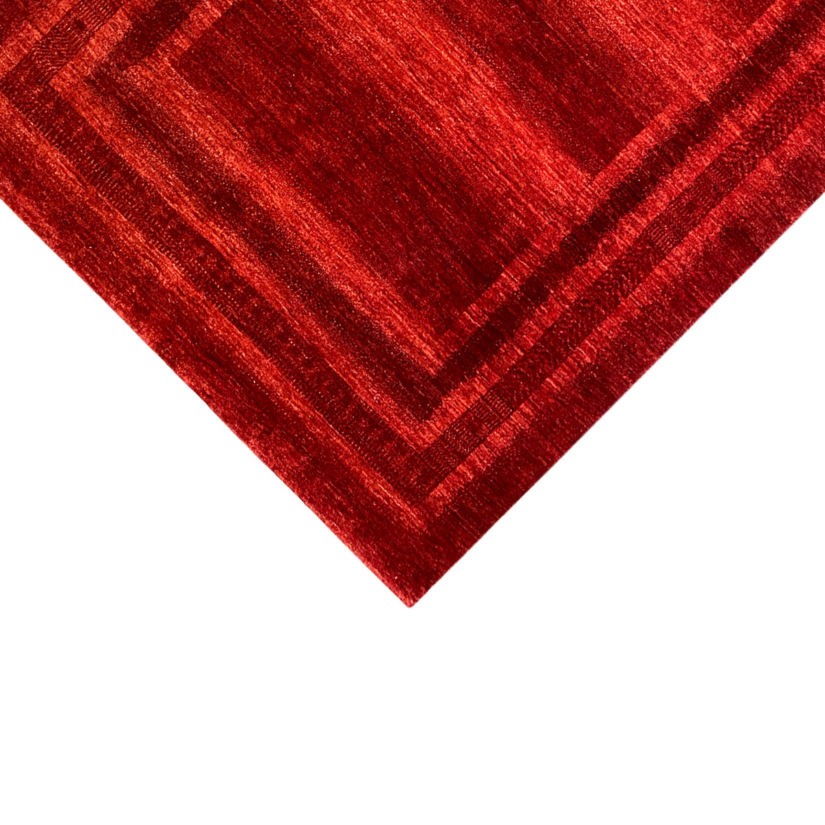 Red carpet detail with patterned lines in a square, shimmering textile surface