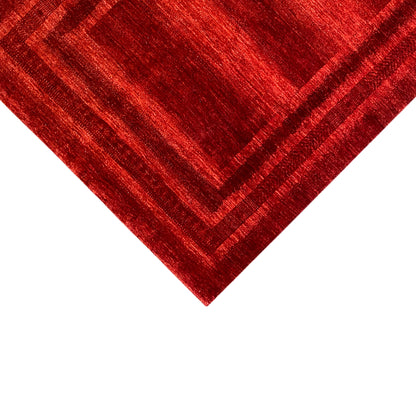 Red carpet detail with patterned lines in a square, shimmering textile surface