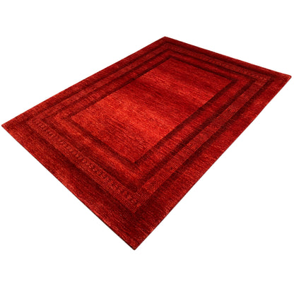 Red Gabbeh Luri rug in diagonal view with a rectangular frame pattern and border