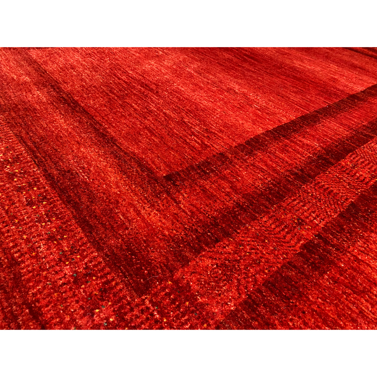 Detailed view of red Gabbeh-Luri rug with a woven texture and multilayered patterned lines
