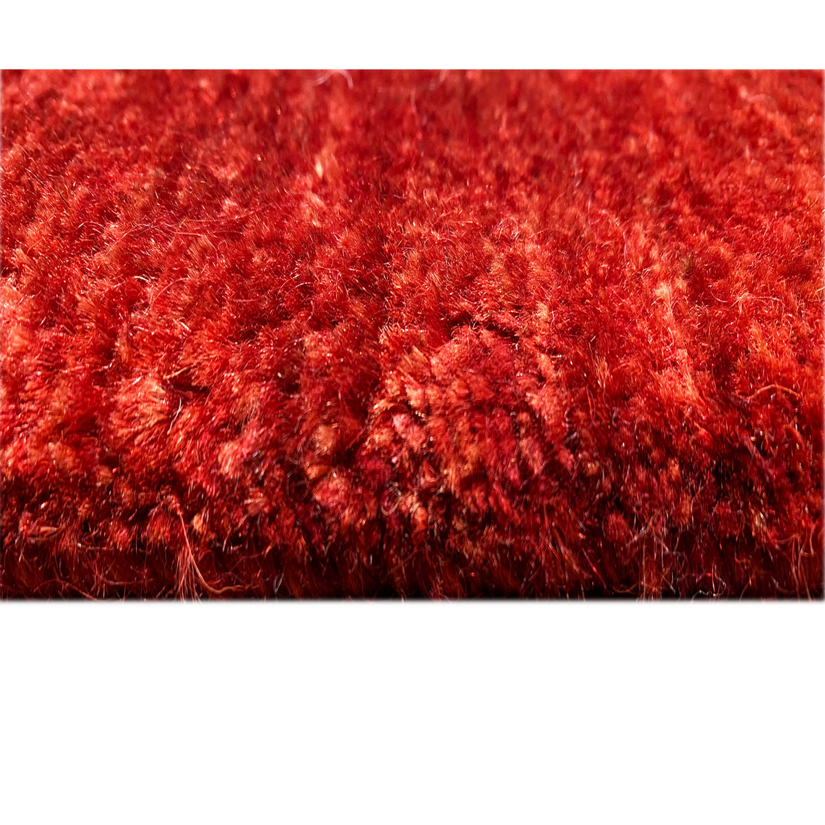 Close-up of the pile surface: red Gabbeh-Luri rug with a dense, glossy-looking texture