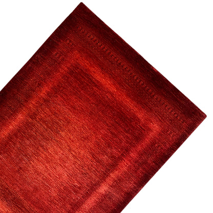Red carpet with a fine linear pattern and woven edge finish, shown at a diagonal angle