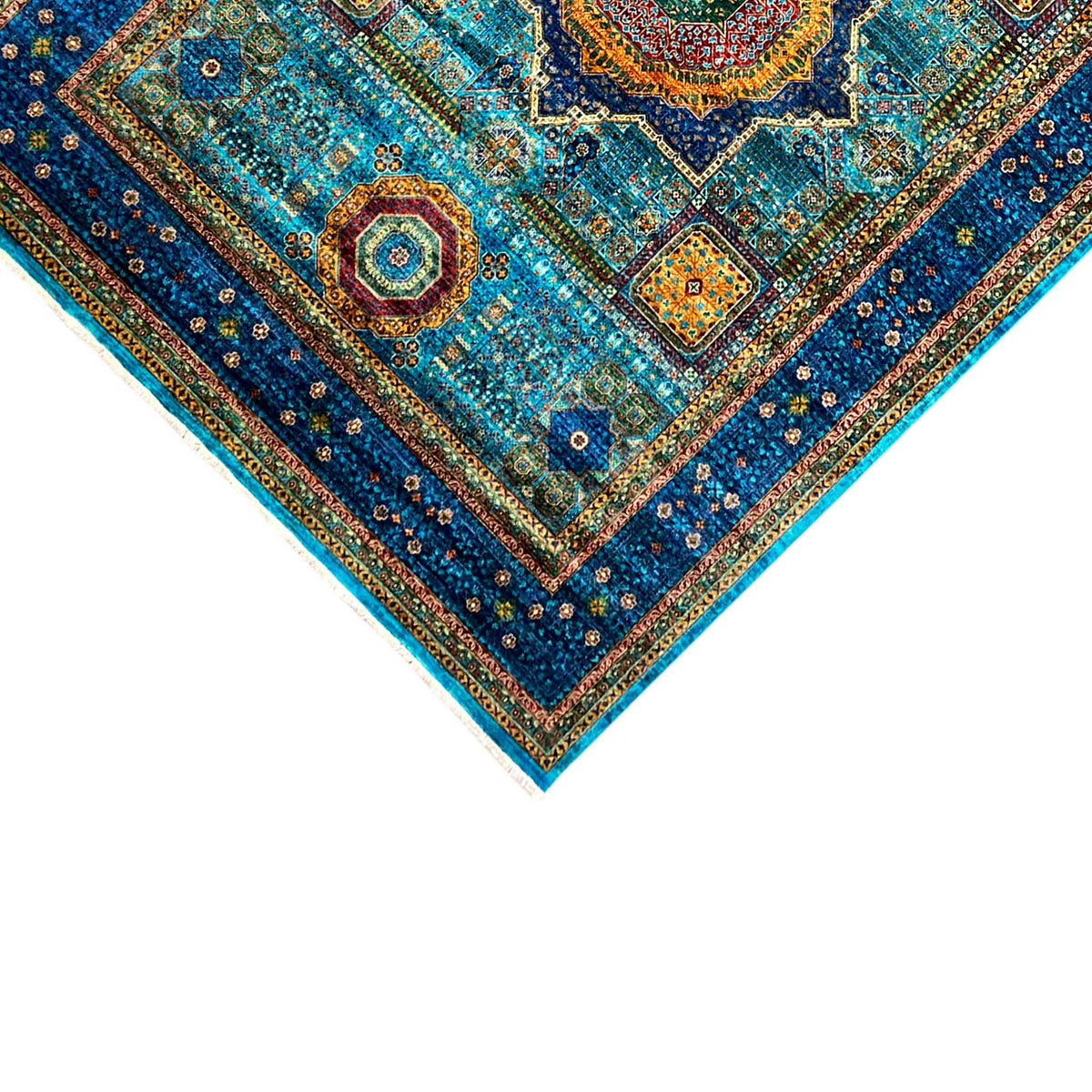 Corner detail of a blue carpet with a border, circular ornaments, and colorful dots