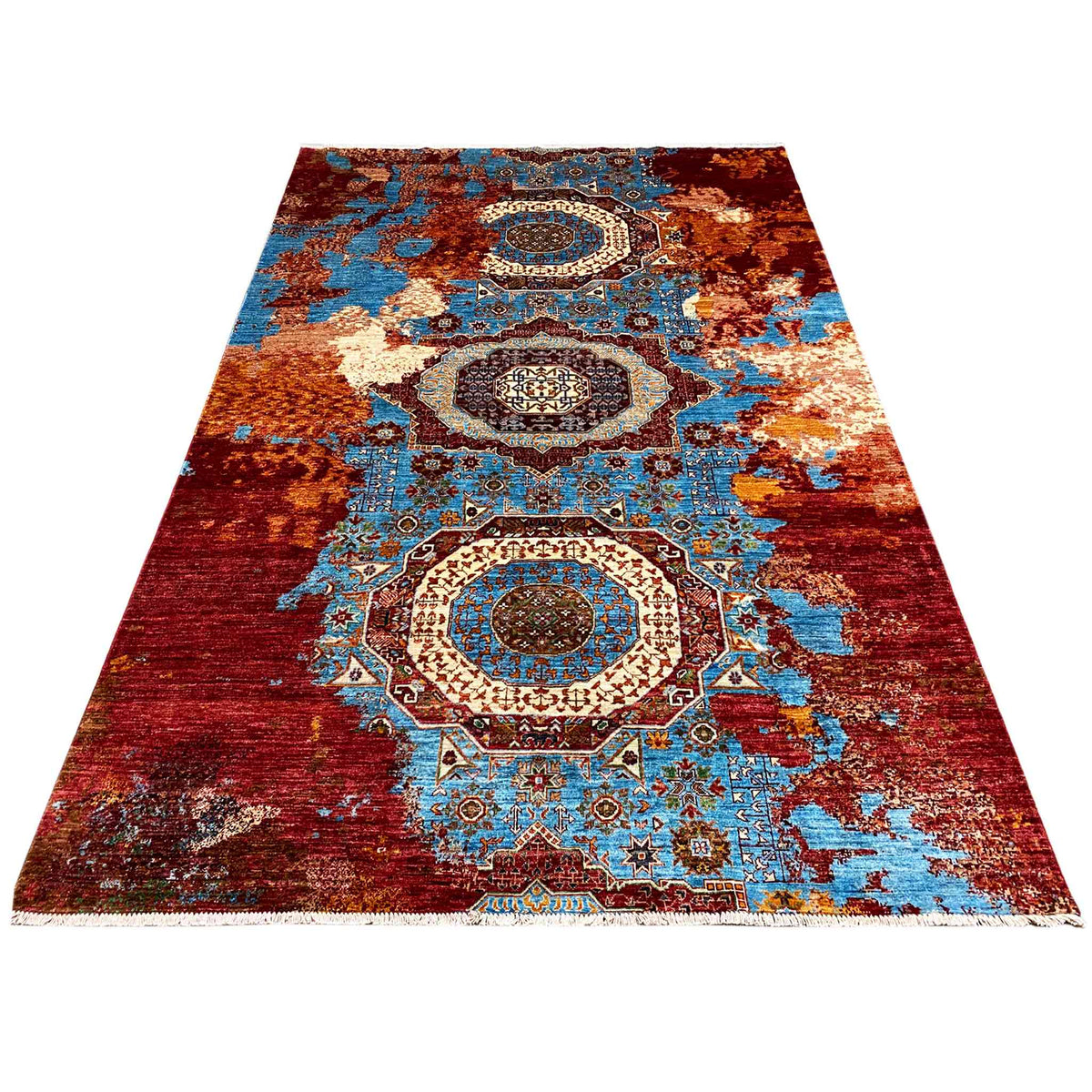 Rectangular rug with medallion and ornamental elements in red, turquoise, and blue