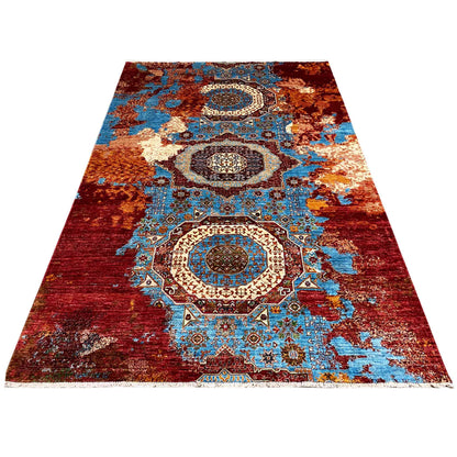 Rectangular rug with medallion and ornamental elements in red, turquoise, and blue