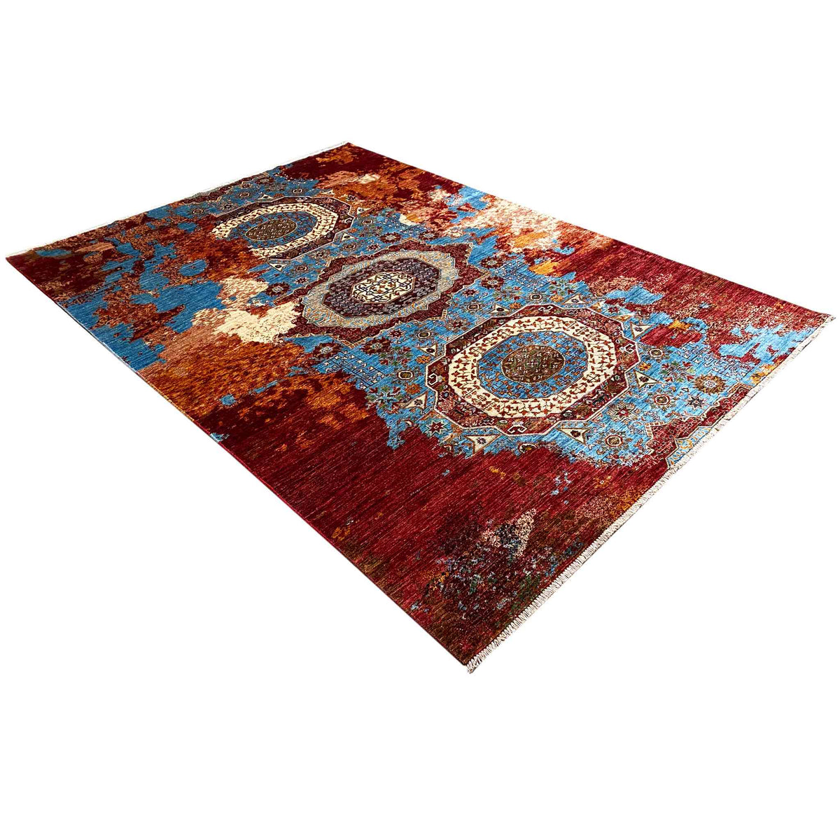 Hand-knotted carpet at an angle: red-and-blue ornaments and medallions