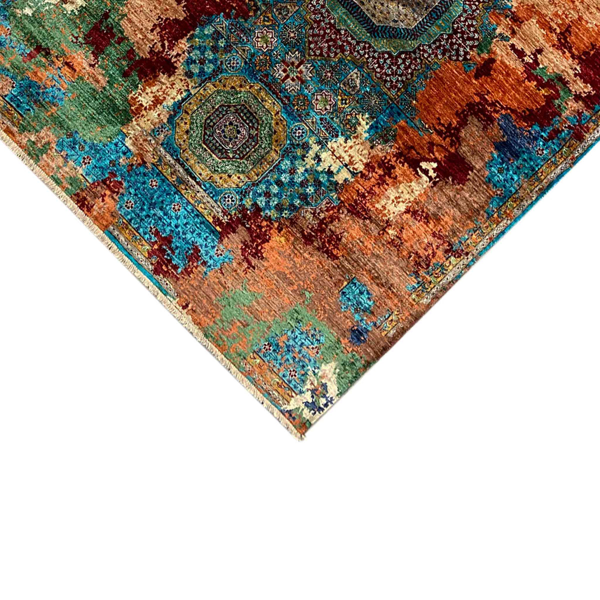 Close-up of the rug corner: medallion motifs in rust brown, teal, and beige