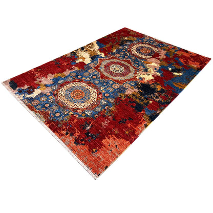 Rug with red areas, blue ornaments, and cream-colored zones, diagonal view