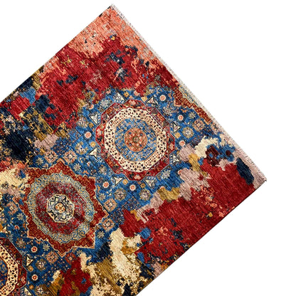 Carpet in corner view with a red background, blue medallion pattern, and beige border