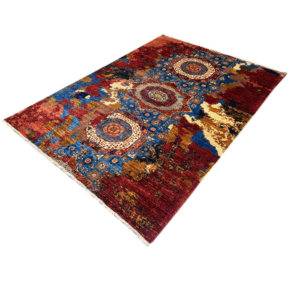 Rug in shades of red, blue, and gold with a central medallion and ornamental corner motifs