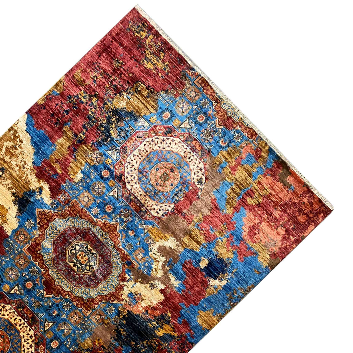 Rug spread out at an angle, with medallions and ornaments in red and blue