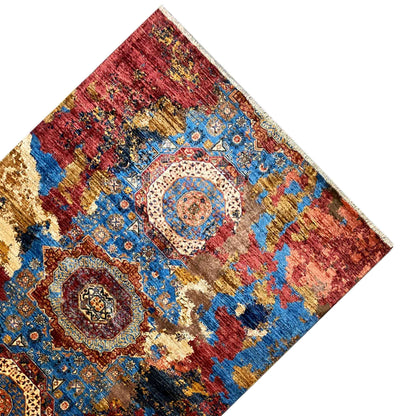 Rug spread out at an angle, with medallions and ornaments in red and blue