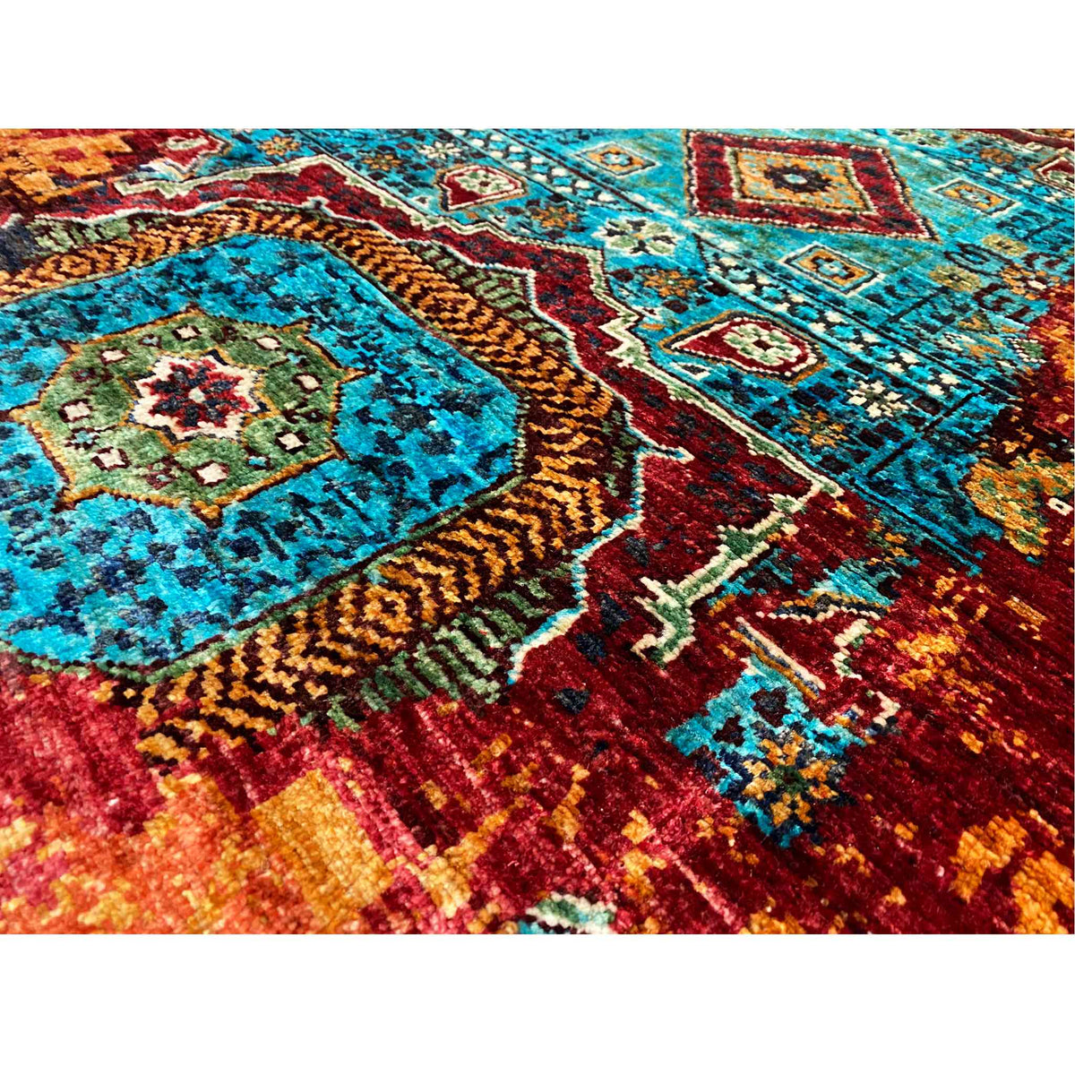 Close-up of a runner rug with bold turquoise and reddish-brown patterns, dense pile