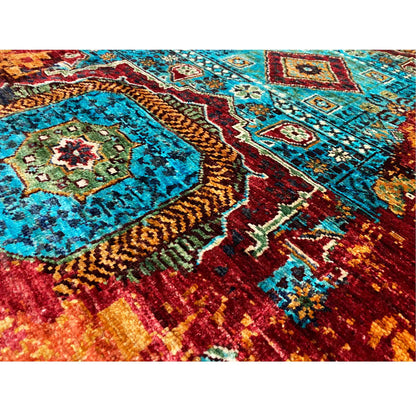 Close-up of a runner rug with bold turquoise and reddish-brown patterns, dense pile