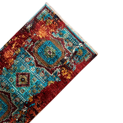 Corner of a runner rug with turquoise medallions and a reddish-brown background, with fringes
