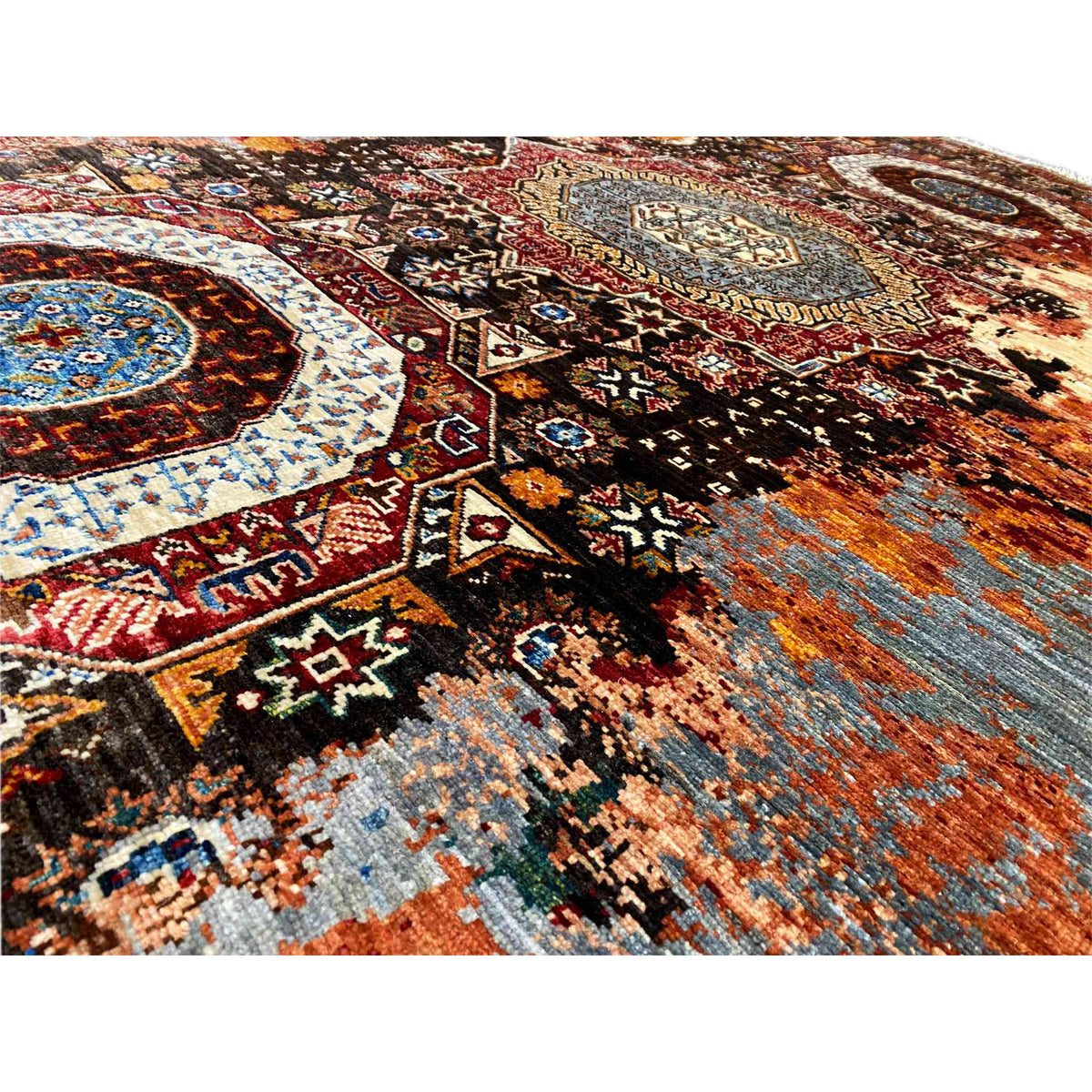 Mamluk carpet detail view: dense ornamental weave in shades of brown, blue, and orange