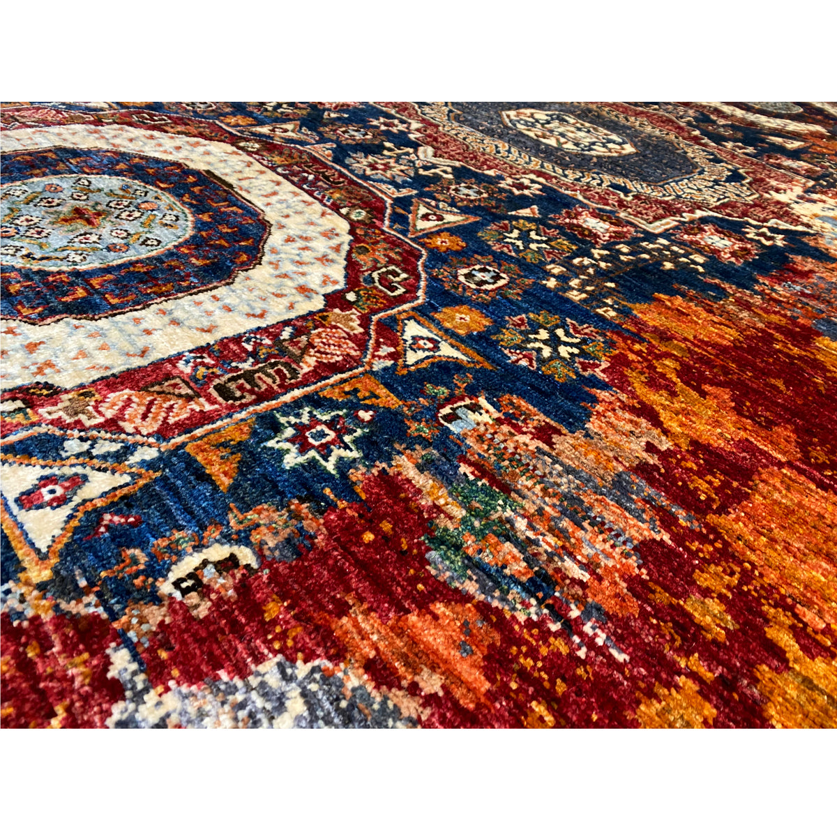Hand-knotted Mamluk rug detail view: bold ornamental areas in blue, red, and beige.