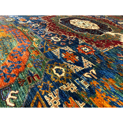Close-up of the handwoven rug: colorful ornaments, blue, orange, red, and golden accents