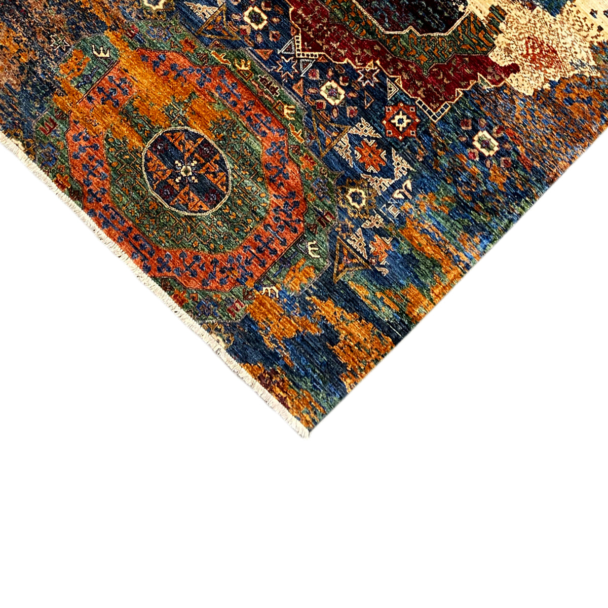 Corner of the hand-knotted Mamluk rug with fringed border and blue-orange ornament