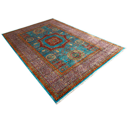 Hand-knotted rug in diagonal view, brown-red base with turquoise accents