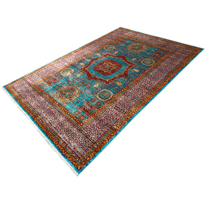 Hand-knotted rug at an angle, detailed ornamental pattern in turquoise and brown