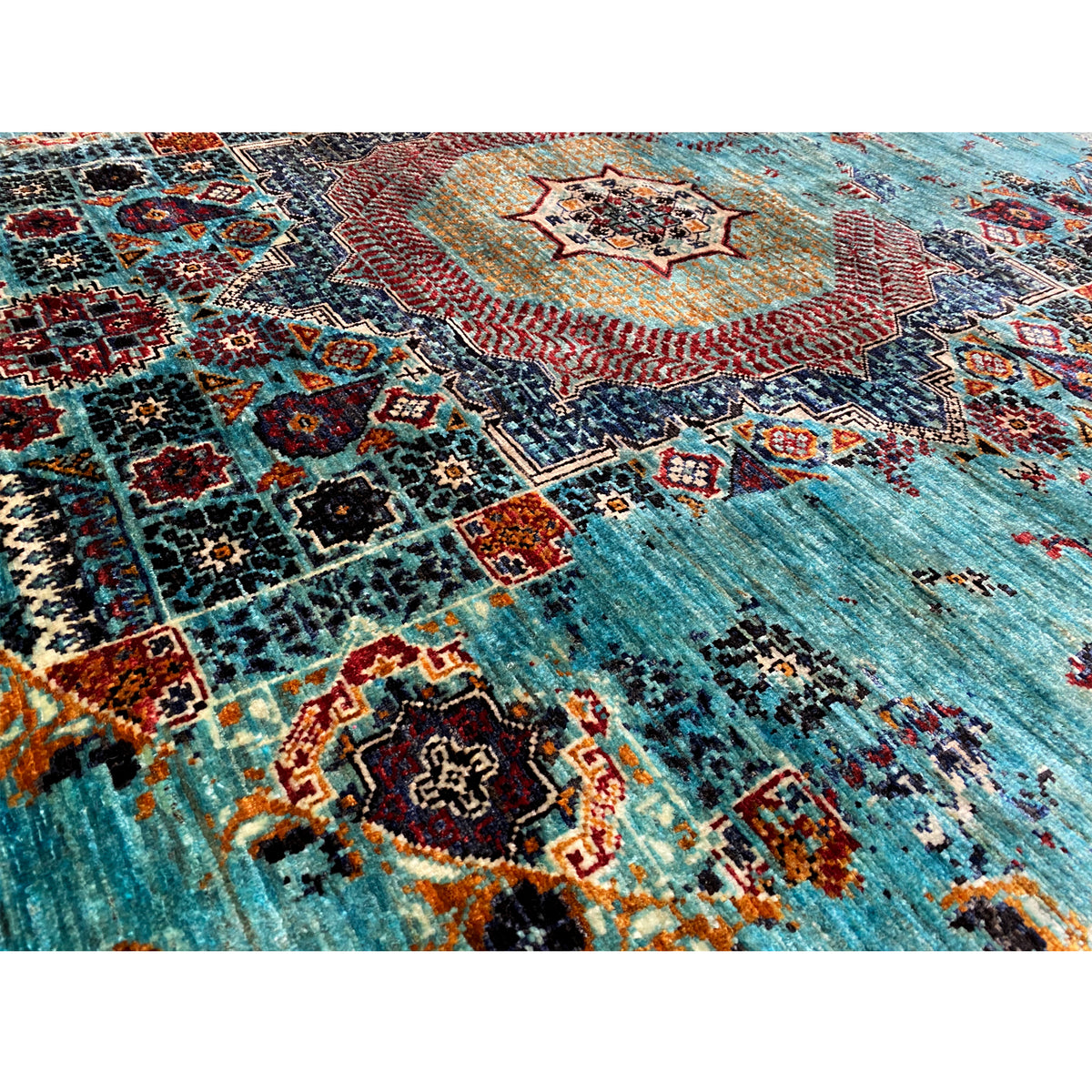 Rug detail: turquoise pile with multicolored ornaments and woven patterns