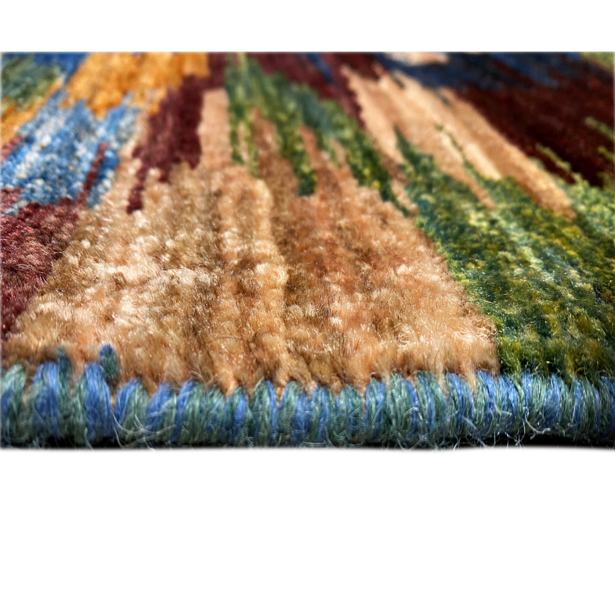 Close-up of the pile of a Mamluk rug: multicolored rug with a blue fringe border.