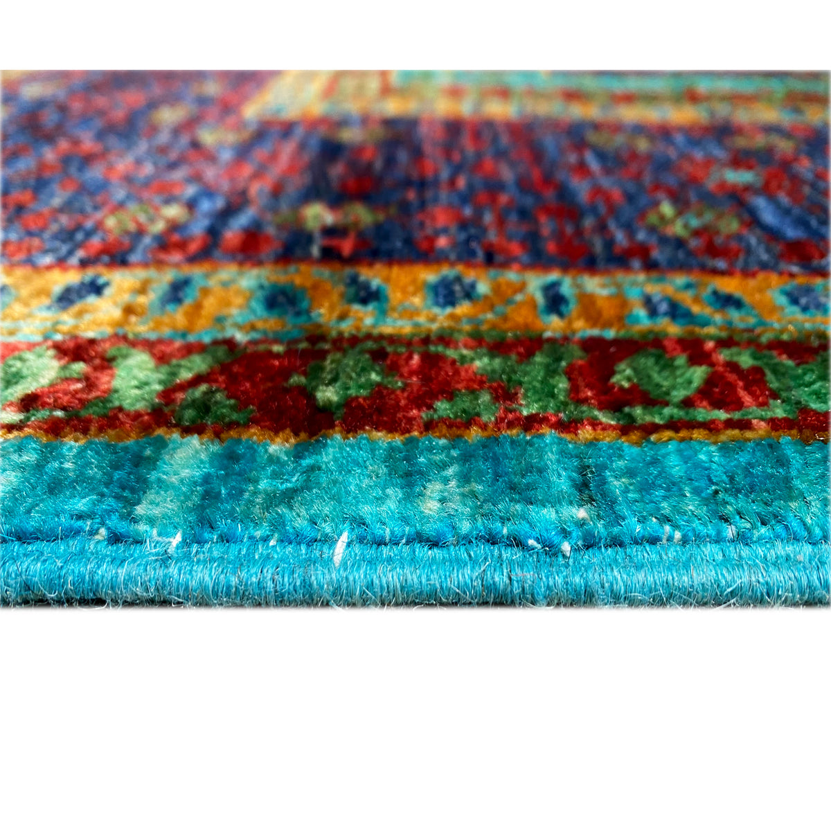 Rug edge with a colorful striped pattern and dense pile in turquoise, dark blue, and red