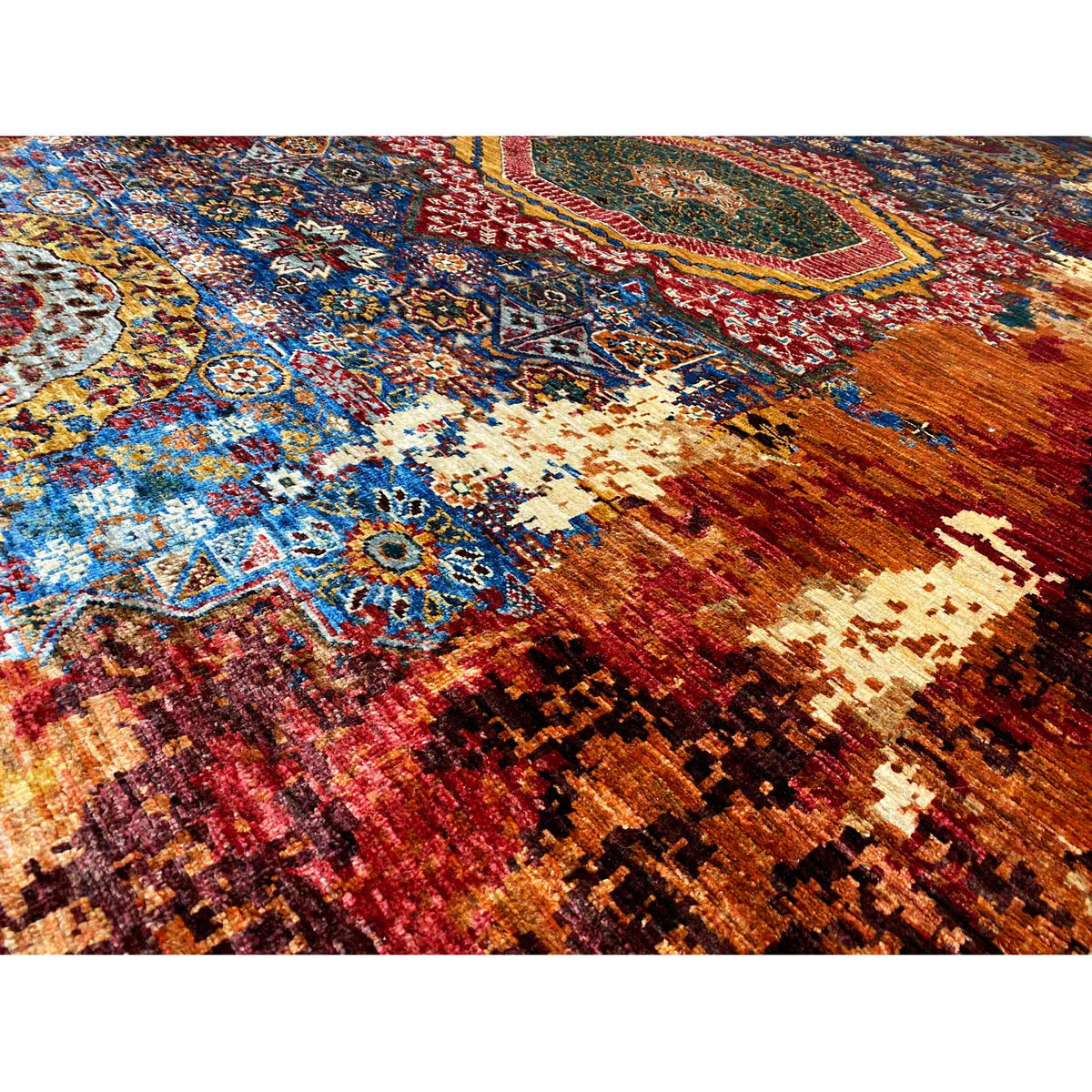 Close-up view of carpet pattern: floral ornaments, blue, red, cream, and rust tones