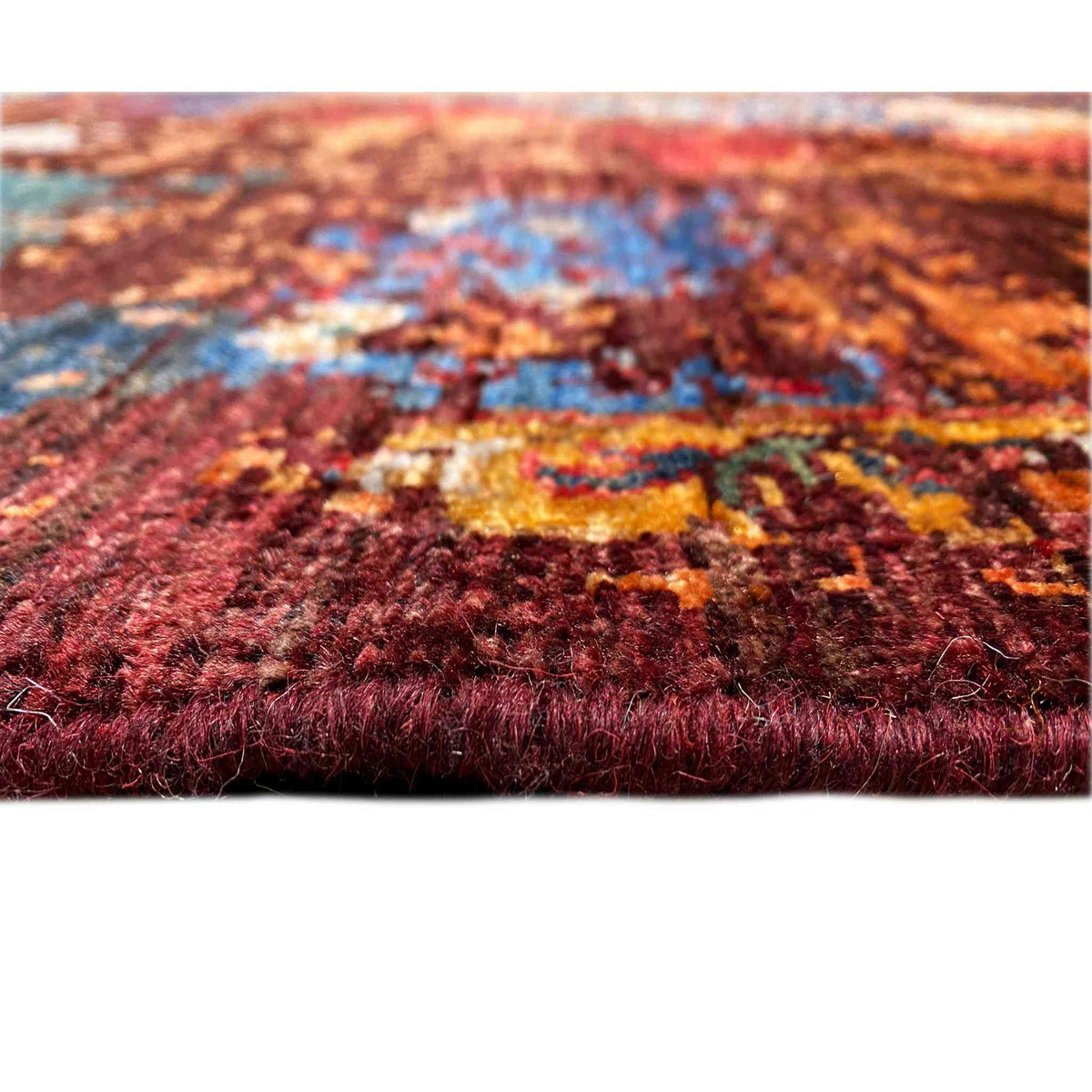 Carpet detail with a dense pile, rich reddish brown, and a blue patterned band
