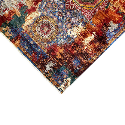 Close-up of rug edge: medallion pattern in blue, red, and cream with a cropped edge