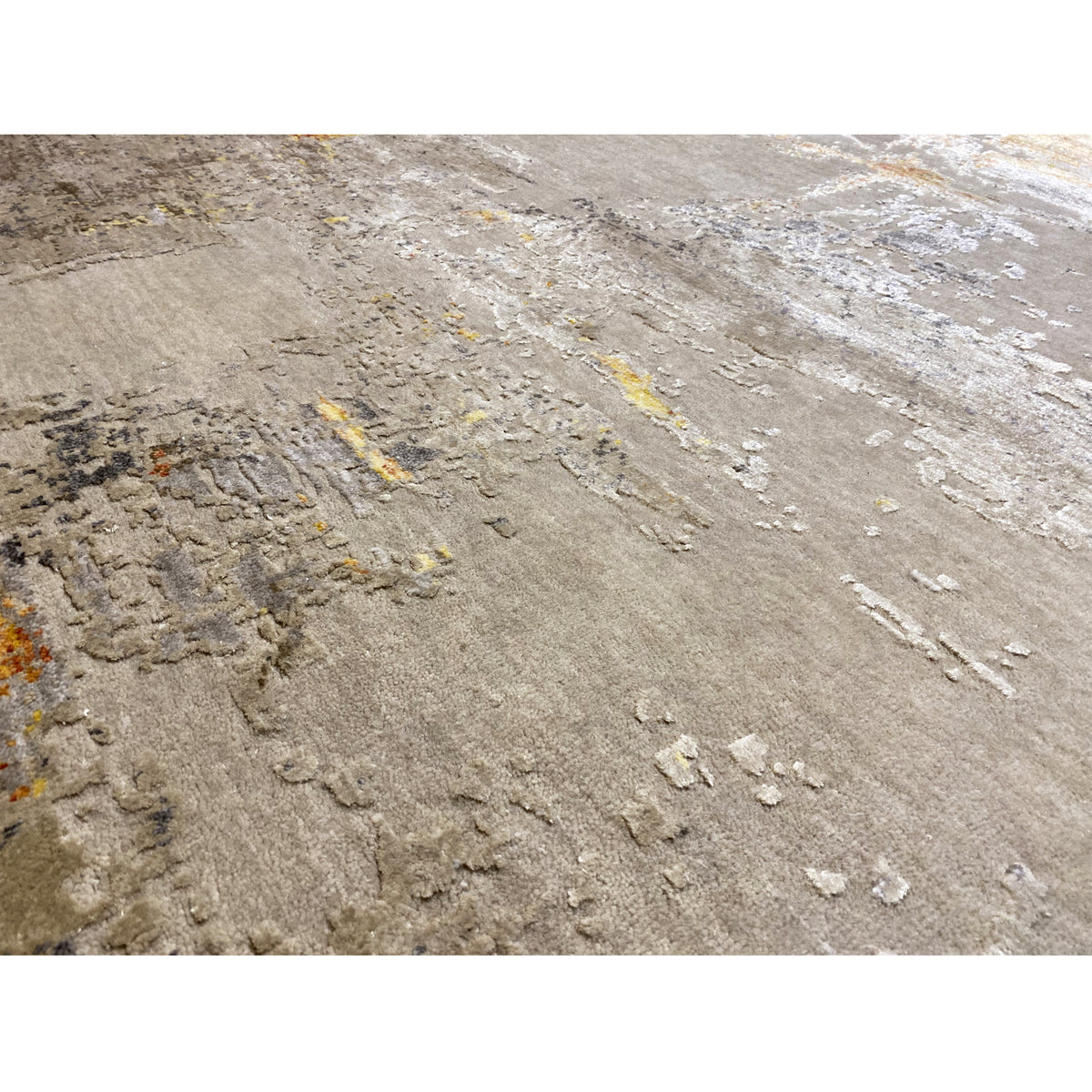 Close-up: Modern rug with a raised vintage pattern in beige, gray, and yellow-orange lines